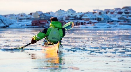 Man in Kajak in de winter in West-Zweden.